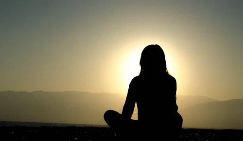 Woman sitting quietly outdoors practicing self-reflection — learning to set healthy boundaries without guilt