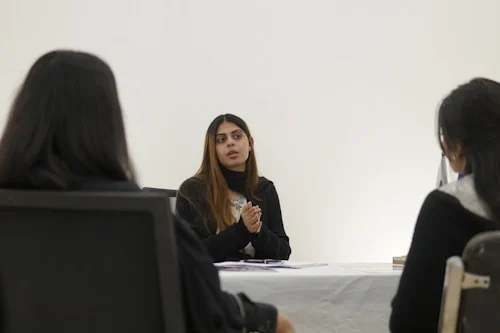 Woman using confident meeting communication phrases while presenting to colleagues in a boardroom