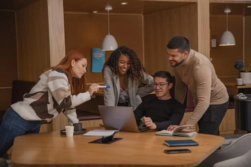 Professionals practicing assertive meeting communication phrases during a team discussion around a conference table