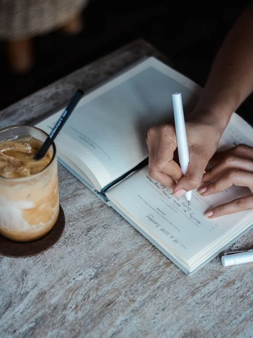 Person journaling at a desk as part of breaking codependency patterns through self-reflection