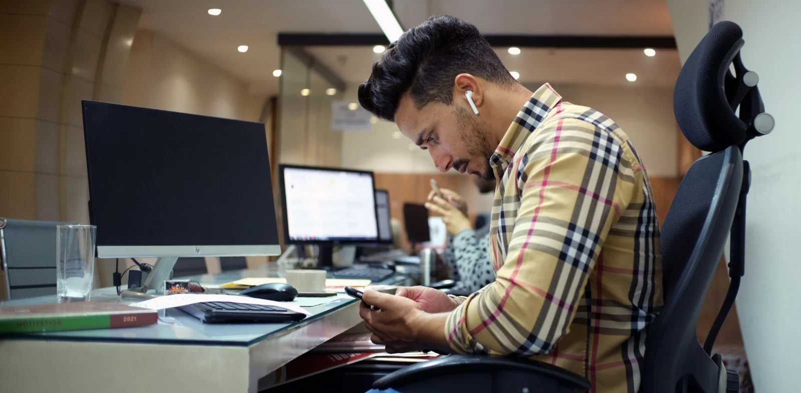 Professional practicing a digital detox by keeping a smartphone face down while working at a desk