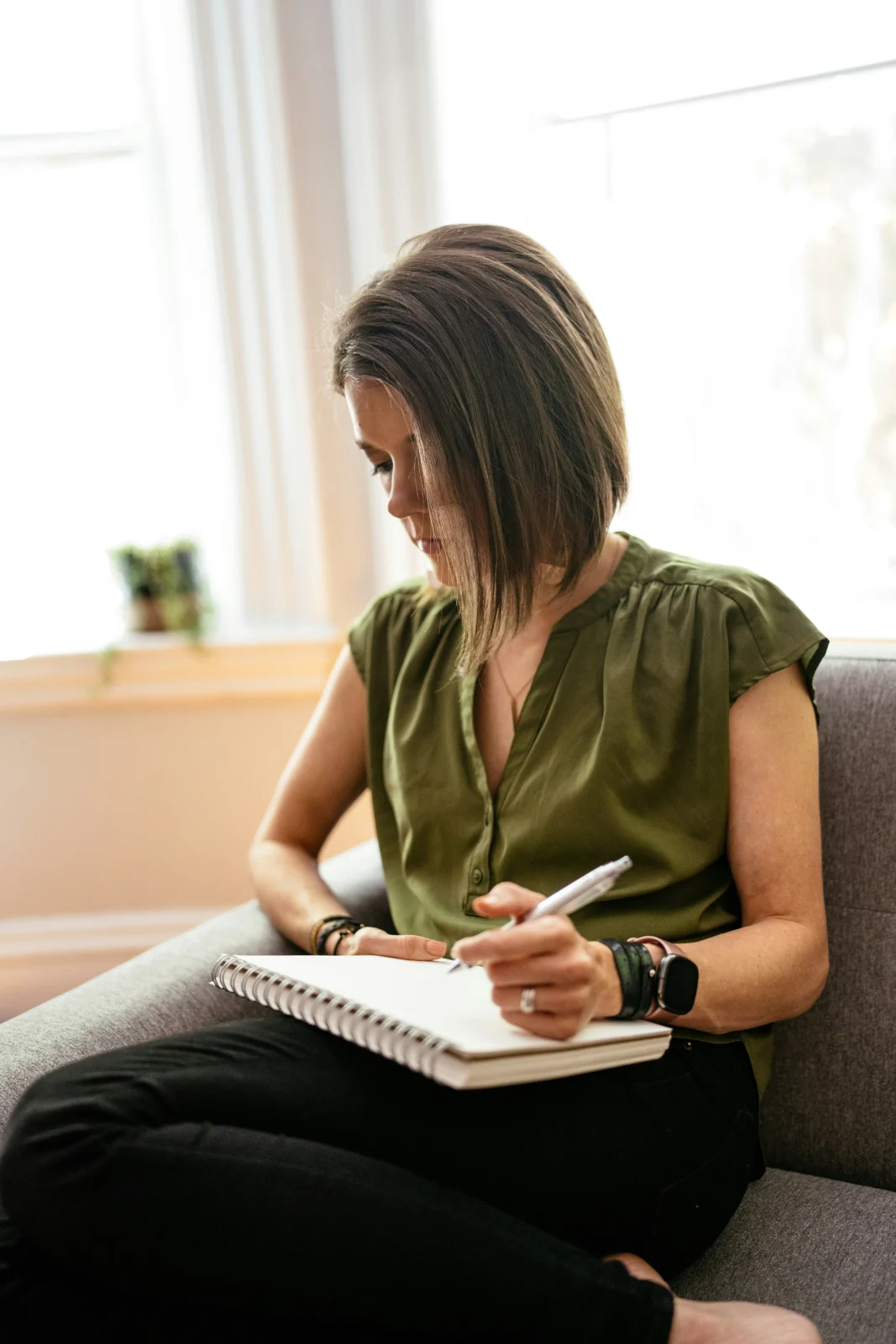 Woman journaling during quiet reflection to build Enneagram self-awareness and recognize personal patterns.