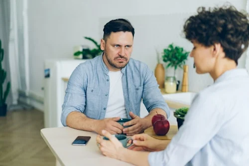 Two people engaged in calm, face-to-face conversation practicing healthy conflict resolution in a relationship