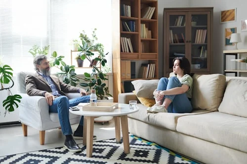 Couple sitting across from each other in honest conversation, representing healthy conflict in relationships