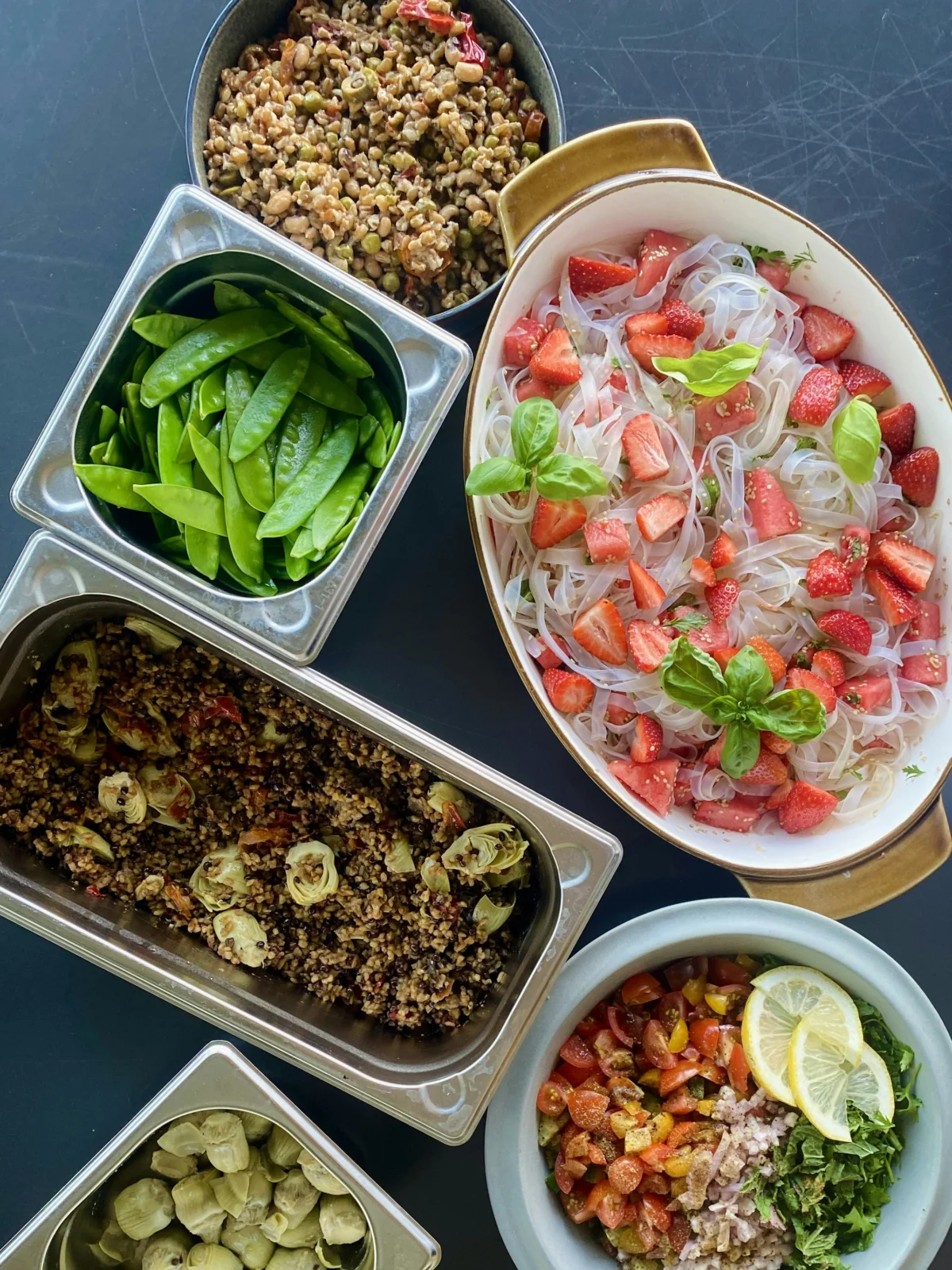 Colorful plant-based eating spread with vegetables, grains, beans, and fresh herbs on a dining table