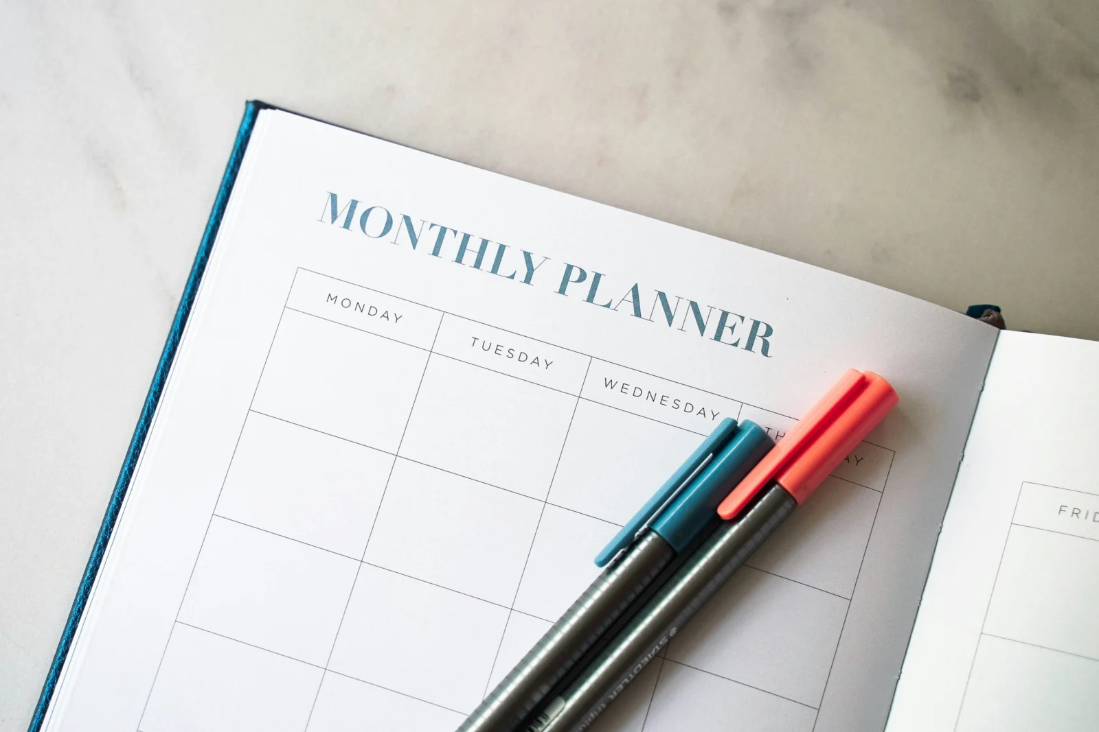 Overwhelmed person reviewing a planner after setting too many goals at once