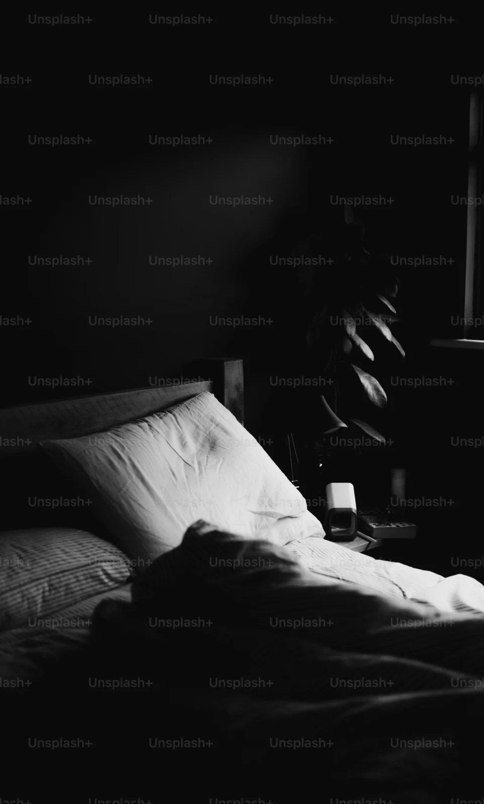 Dark, calm bedroom for better sleep with soft bedding and minimal nighttime light