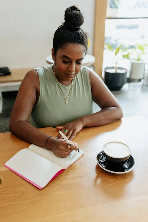 Person journaling at a desk as a daily practice for developing high emotional intelligence and self-awareness